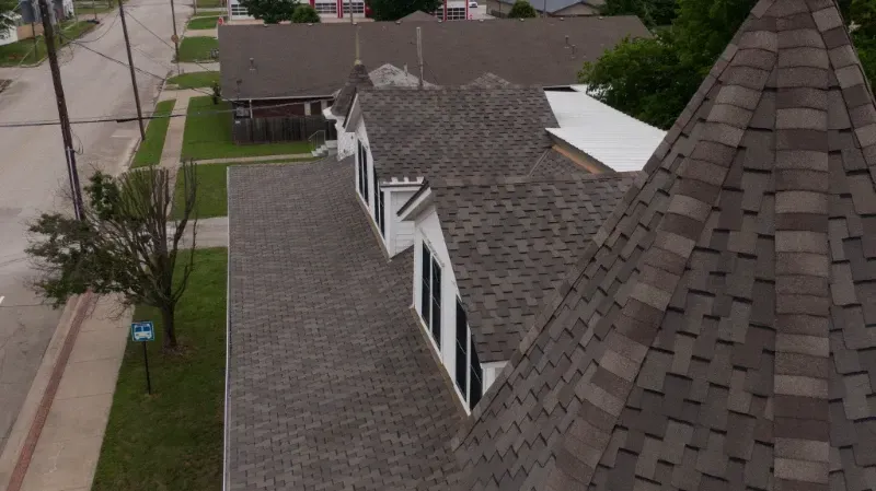 An aerial view of a house with a roof that has shingles on it.