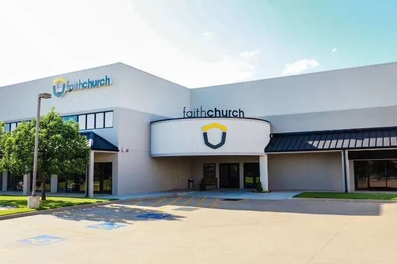 A large white building with a sign that says faithchurch on it.
