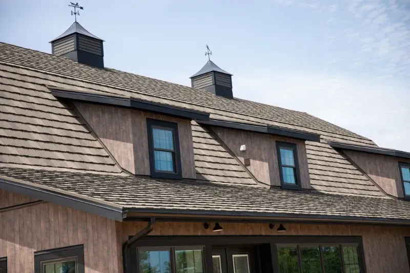 The roof of a house with a weather vane on top of it.