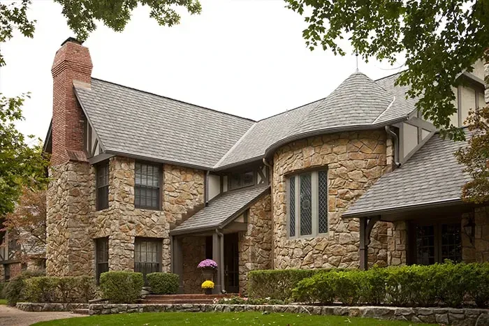 A large stone house with a gray roof