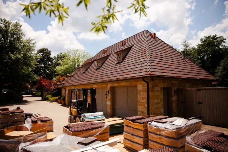 A large house with a brown roof is being remodeled.