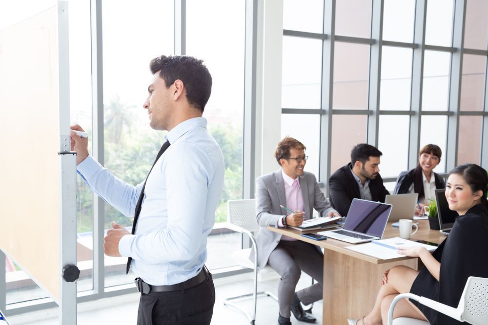 A man is giving a presentation to a group of people in an office.