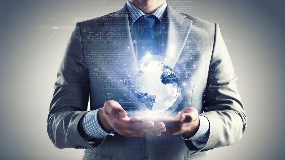 A man in a suit and tie is holding a glowing globe in his hands.