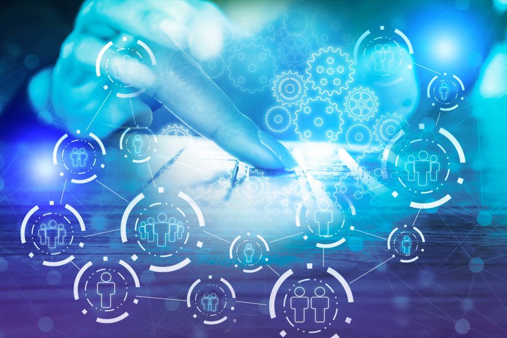 Finger tapping on a phone screen with glowing digital network of people and gears overlaid.