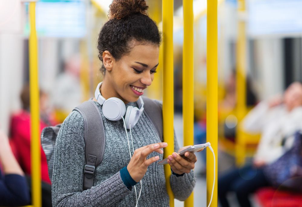 woman looking at smart phone on subway