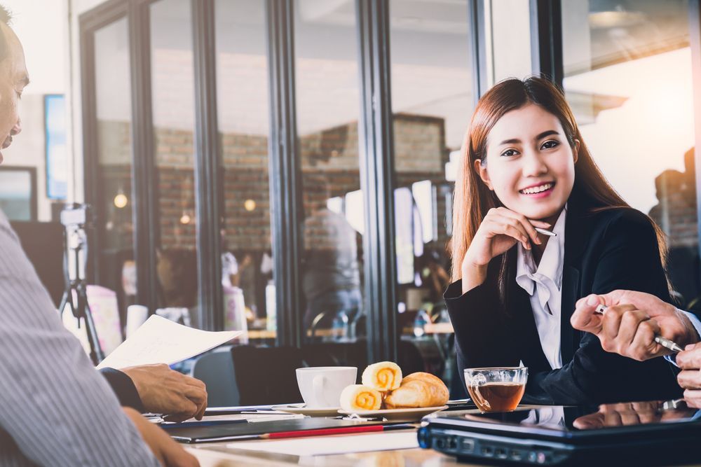 A group of people are sitting at a table having a meeting.