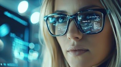 A woman wearing glasses is looking at a computer screen.