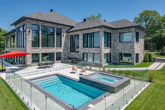 Une grande maison avec une grande piscine devant.