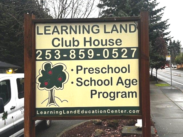 Sign for Learning Land Club House with phone number and program details.
