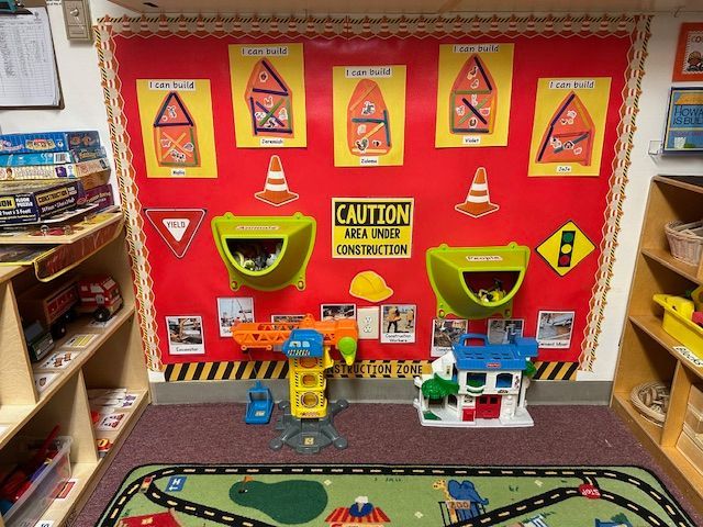 A preschool classroom with sinks, cabinets, bulletin boards, and organizational storage.
