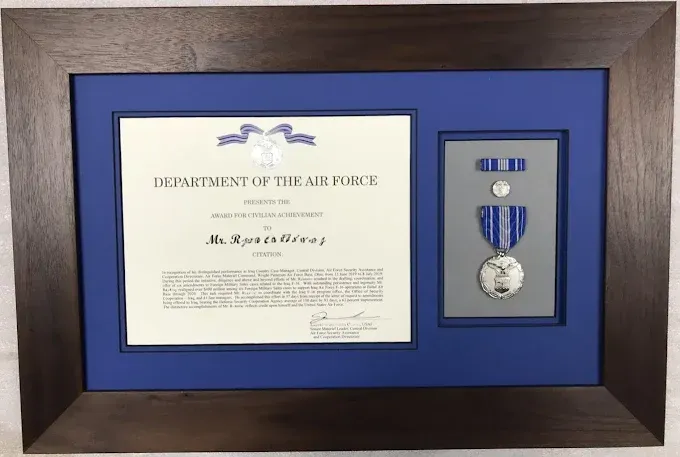 Framed Air Force certificate and medals display, blue matting, brown frame.