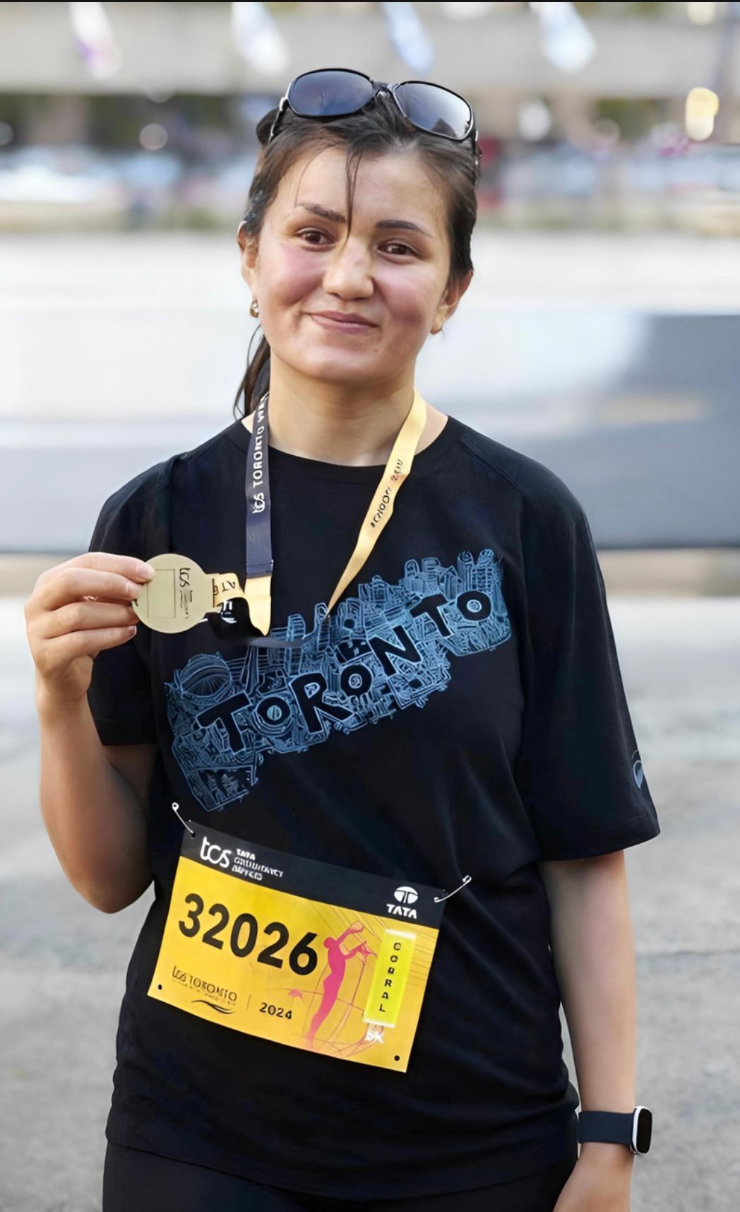 Woman with medal, bib #32026, wearing a 