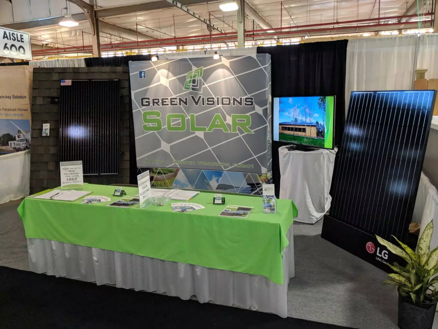 a table with a green tablecloth and a sign that says green visions solar