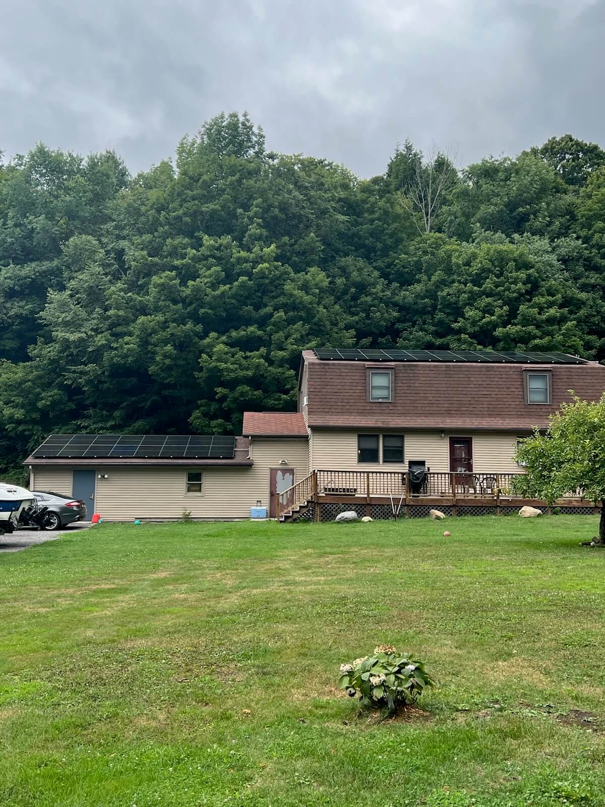 a house is sitting in the middle of a lush green field surrounded by trees 