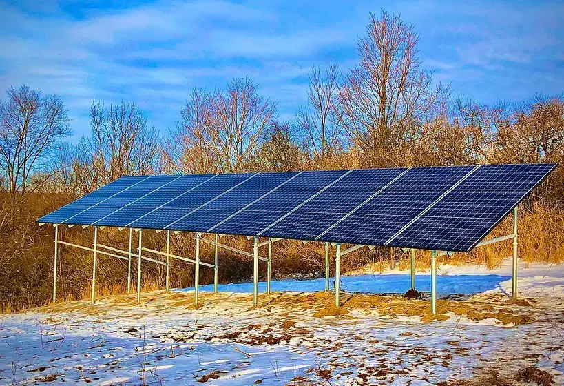 a row of solar panels sitting on top of a snow covered field .