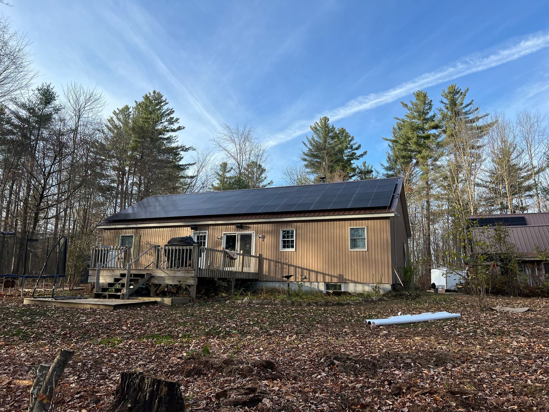 a house with solar panels on the roof is surrounded by trees 
