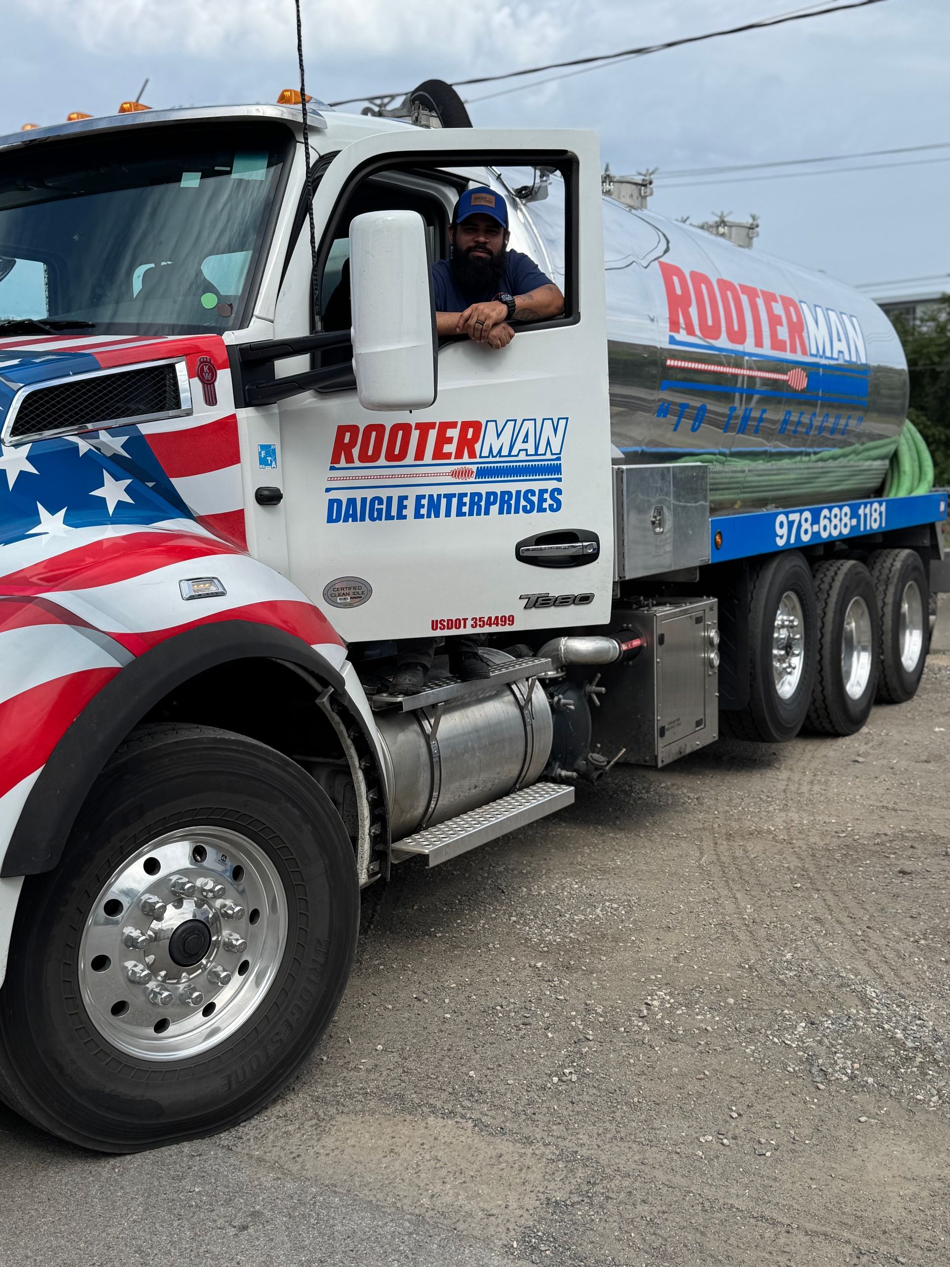 A person's hand washing a container in a stainless steel kitchen sink under running water.