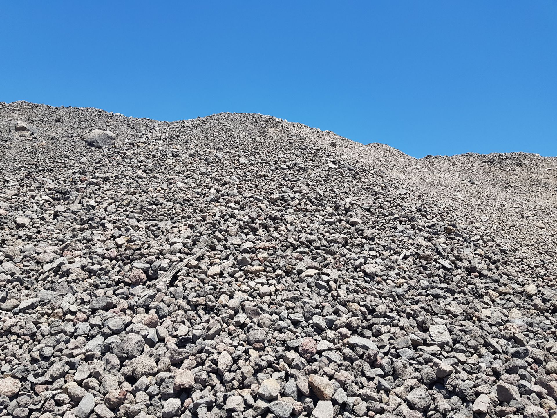 A large pile of rocks against a blue sky.