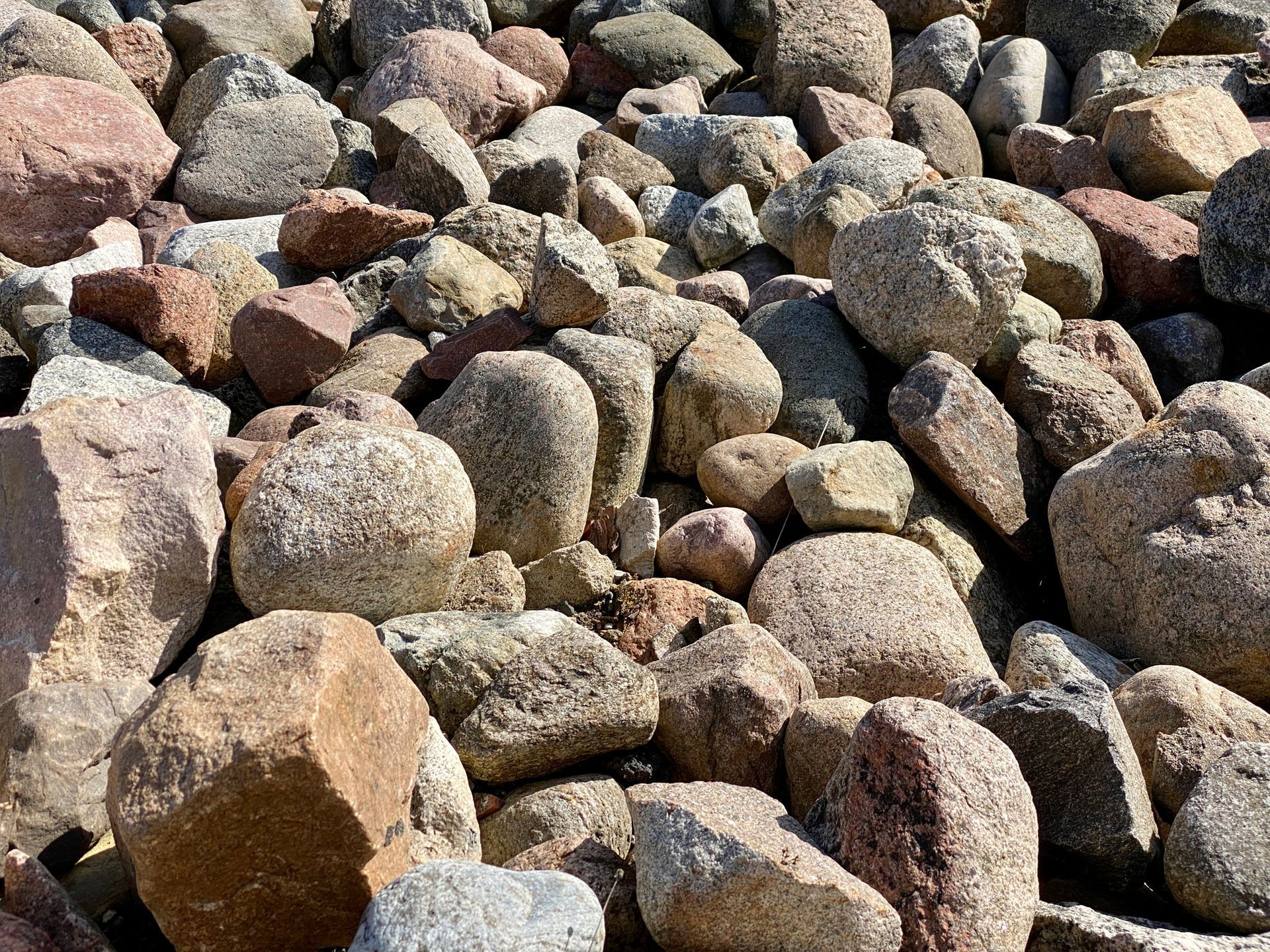 A pile of rocks sitting on top of each other on the ground.