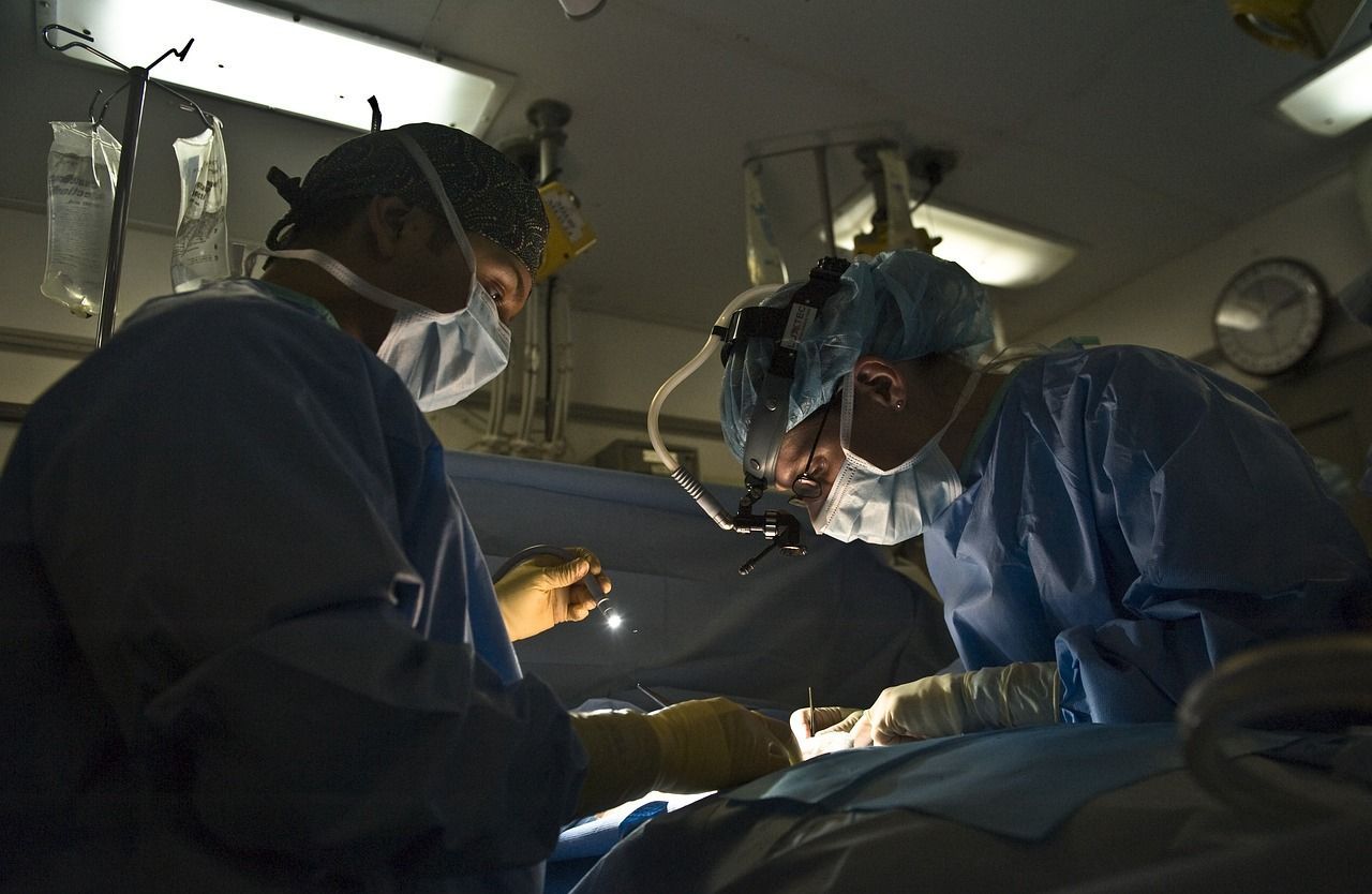 Two surgeons are operating on a patient in an operating room.