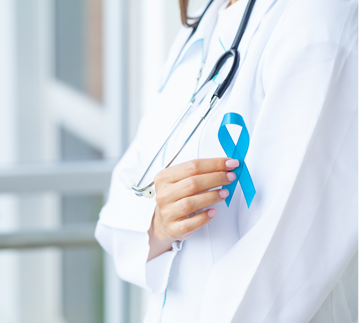 A doctor is holding a blue ribbon on her chest.