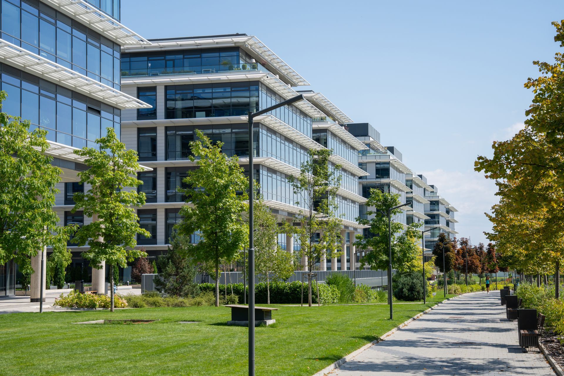 Modern office buildings with a green walkway.