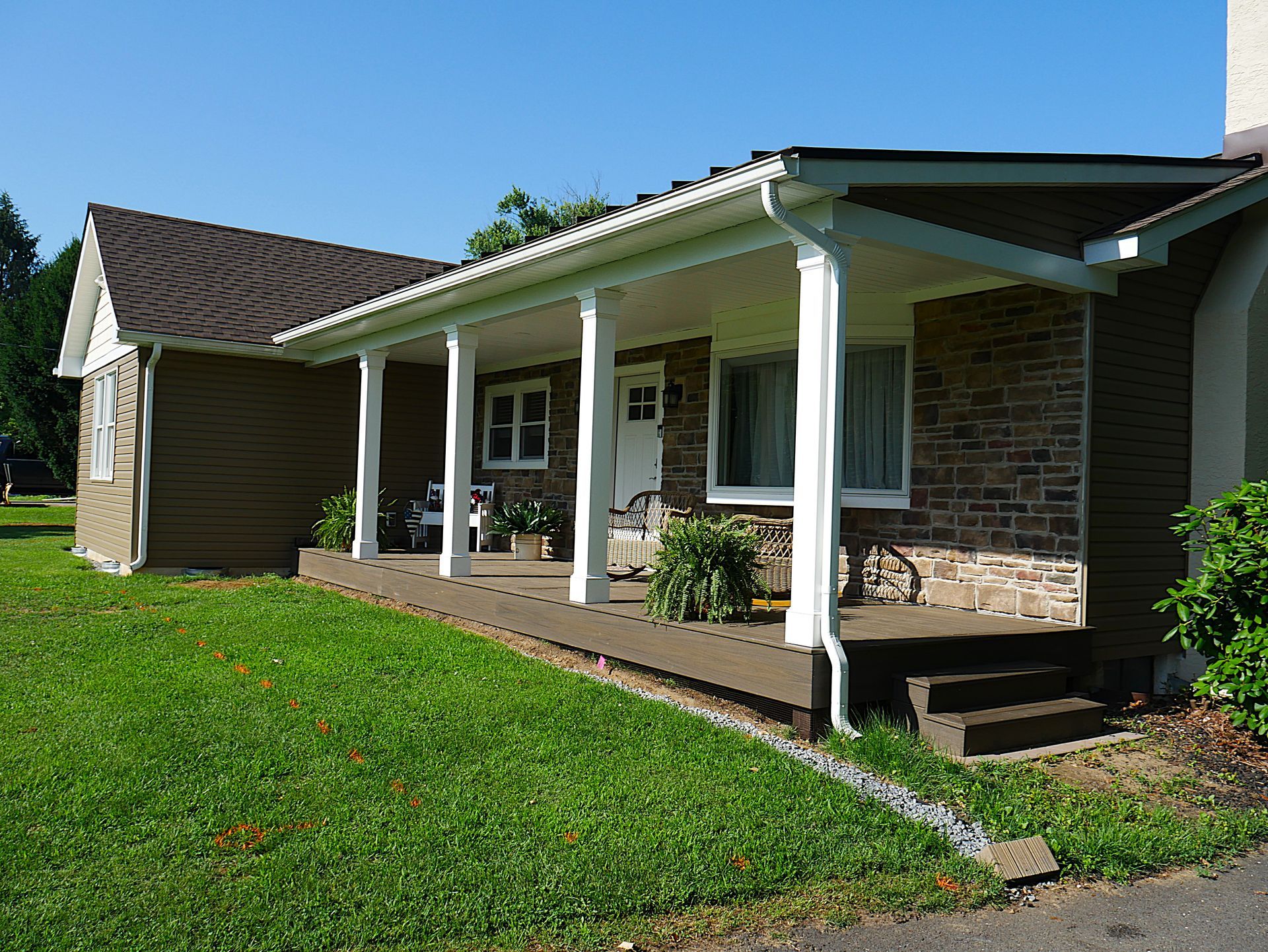 A brick house with a porch and chairs on it
