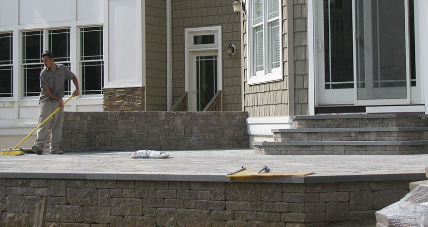 A Man Is Sweeping A Patio — Columbus, NJ — G & G Landscaping Construction, Inc. A Man Is Sweeping A Patio — Columbus, NJ — G & G Landscaping Construction, Inc.