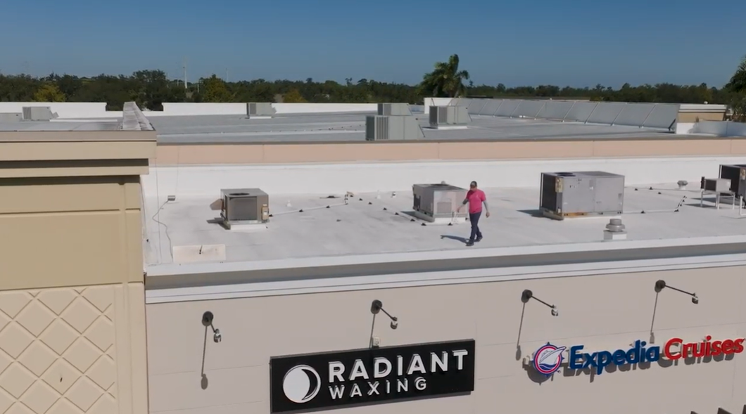 Rooftop with HVAC units and a worker in pink near Radiant Waxing and Empire Cl...