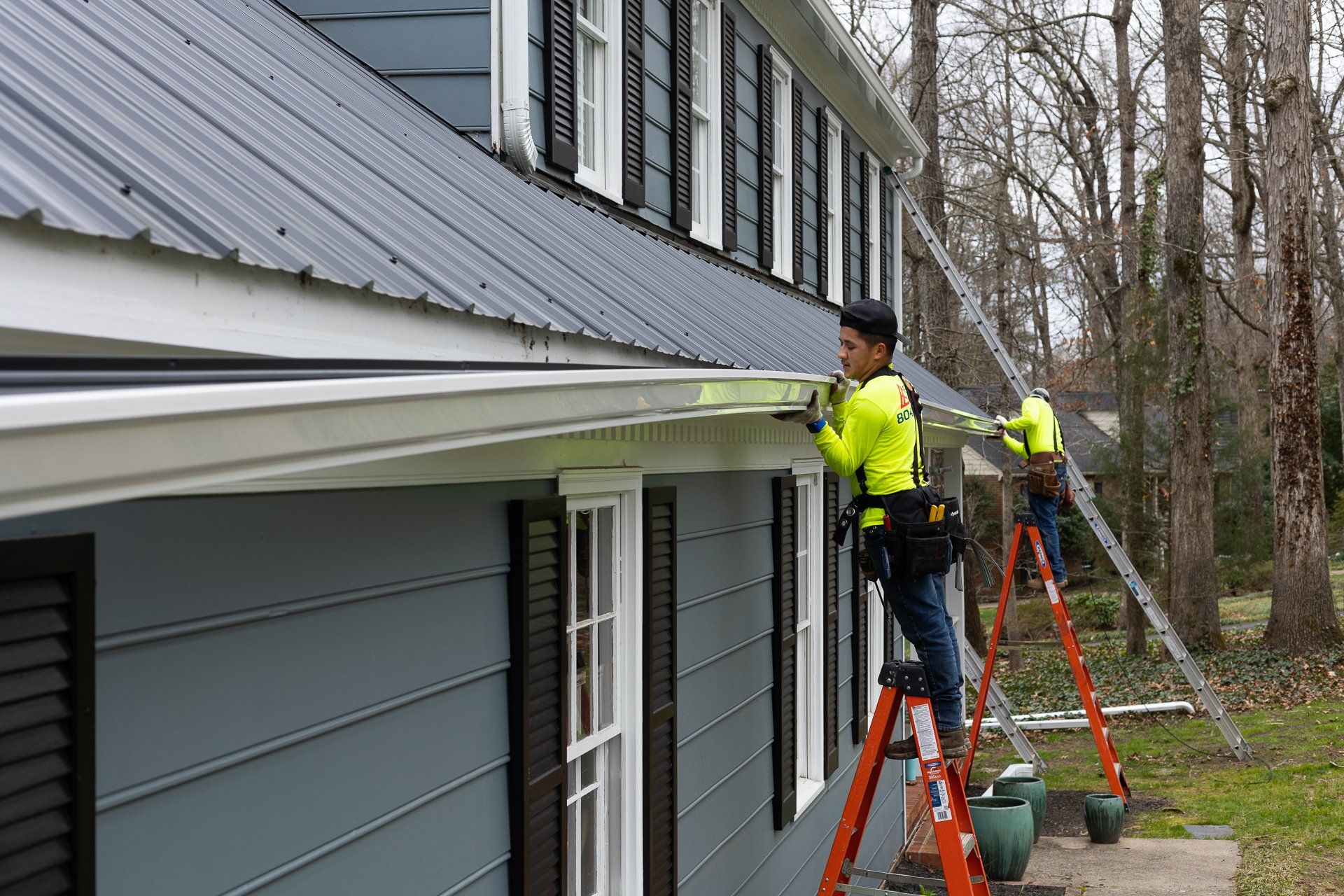 A Retex crew installs new PlyGem DuoPro gutters on a home.