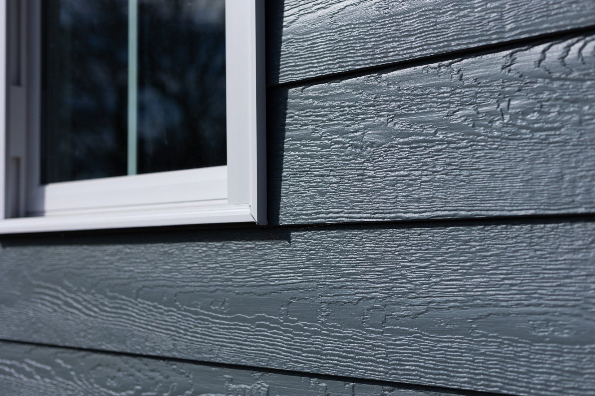 A close-up image of newly installed LP Smartside siding and a Provia window on a new-construction Richmond VA home.