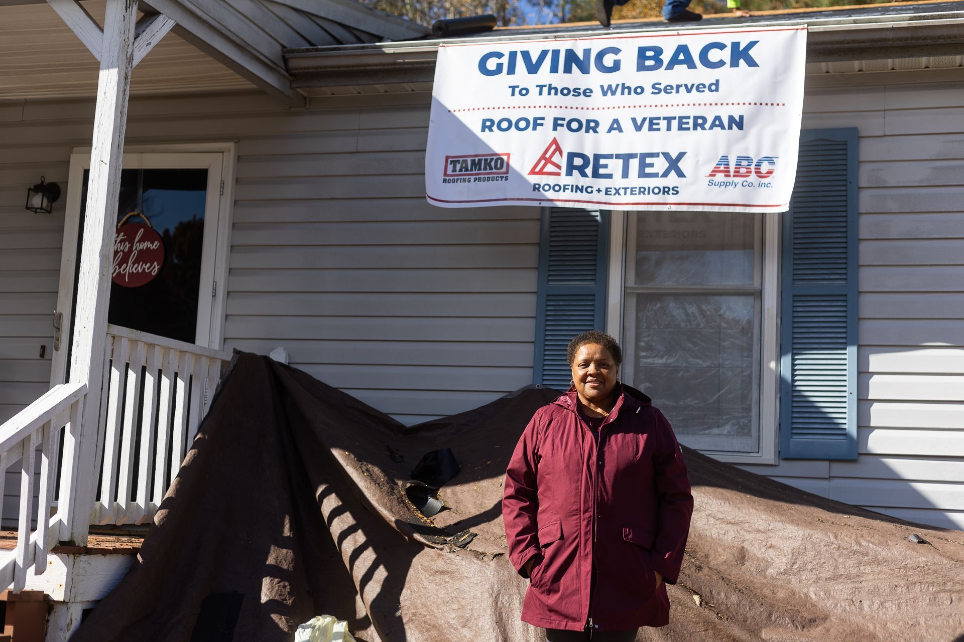 Mrs. Carol Coleman, our Roof For A Veteran 2025 recipient, stands in front of her home during the roof installation, Nov. 10, 2025.
