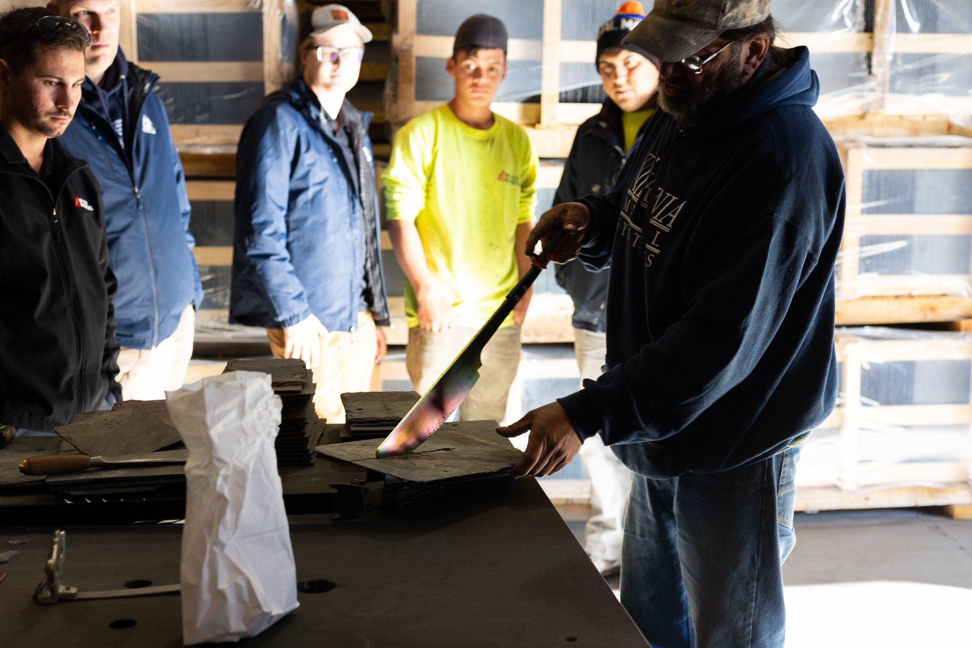 An image of a Virginia slate manufacturer's employee showing how to cut natural slate during a team training event.