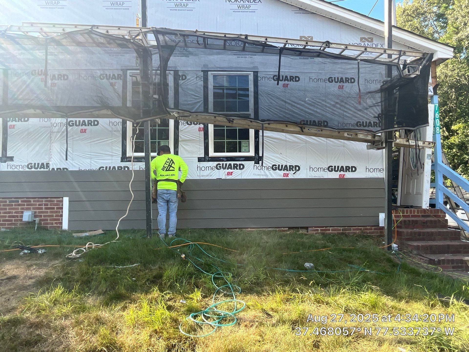 A RETEX employee installs Hardie Plank fiber cement siding at our new RETEX office location.