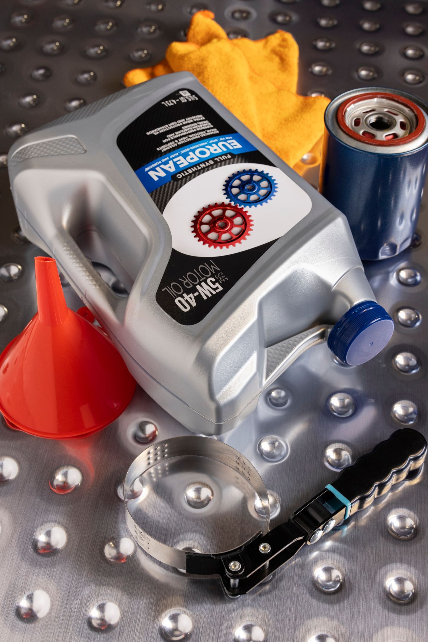 A bottle of motor oil is sitting on a metal surface.