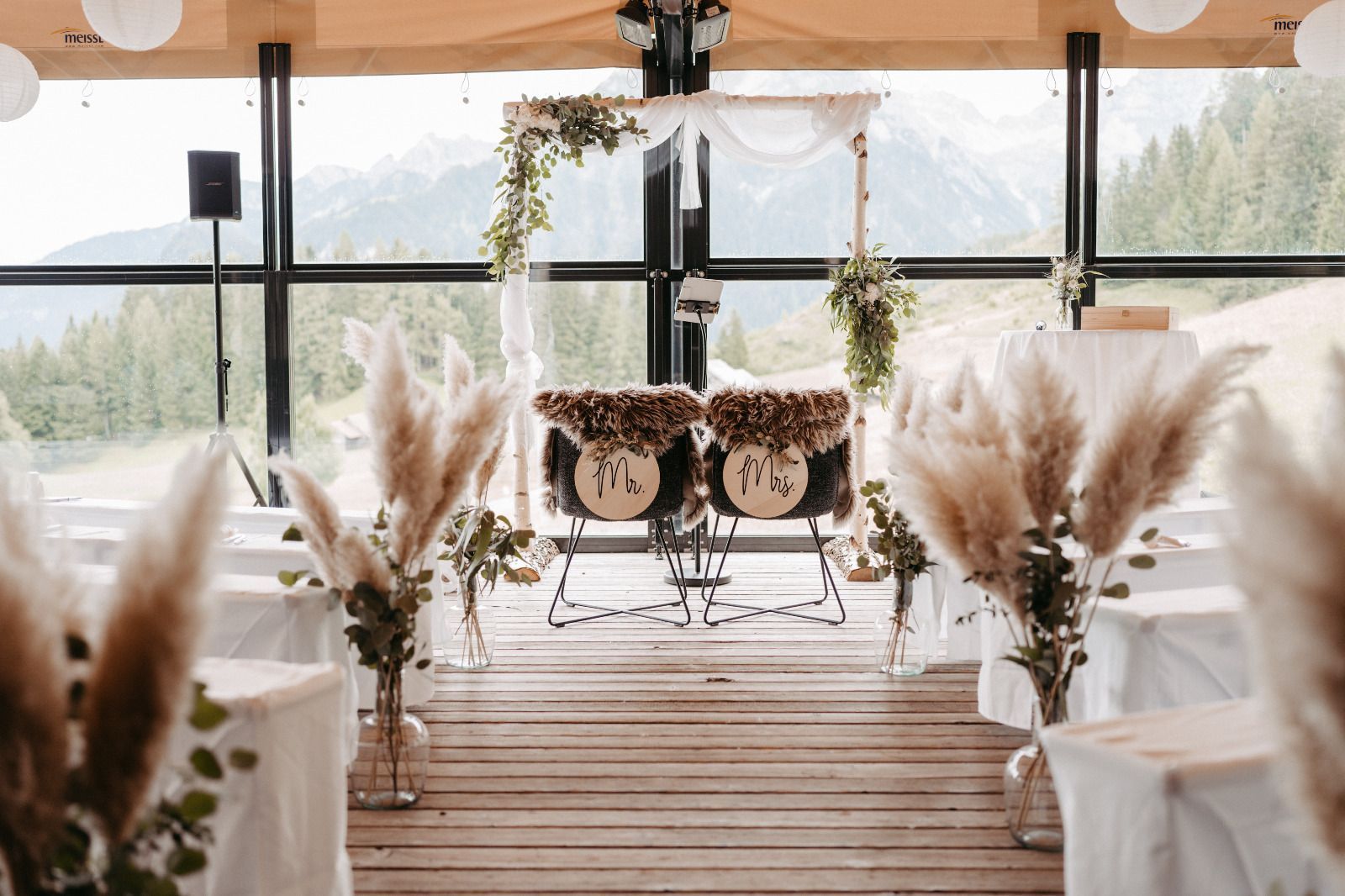 In einem Raum mit Tischen und Stühlen findet eine Hochzeitszeremonie statt.