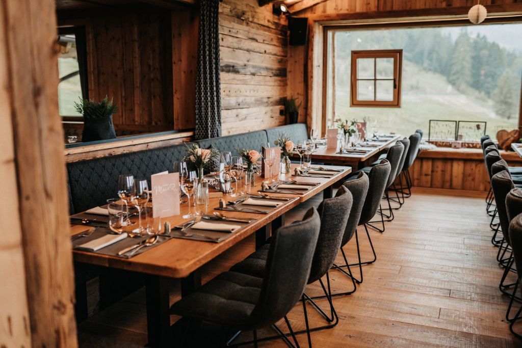 Ein Speisesaal mit Tischen und Stühlen, aufgestellt für einen Hochzeitsempfang.