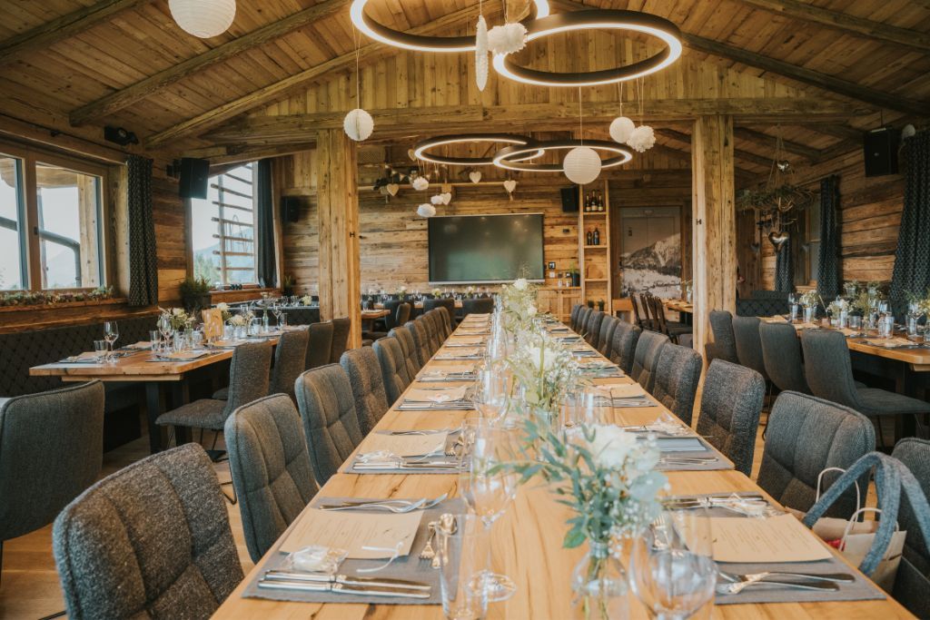 Ein langer Holztisch mit vielen Stühlen in einem Restaurant.