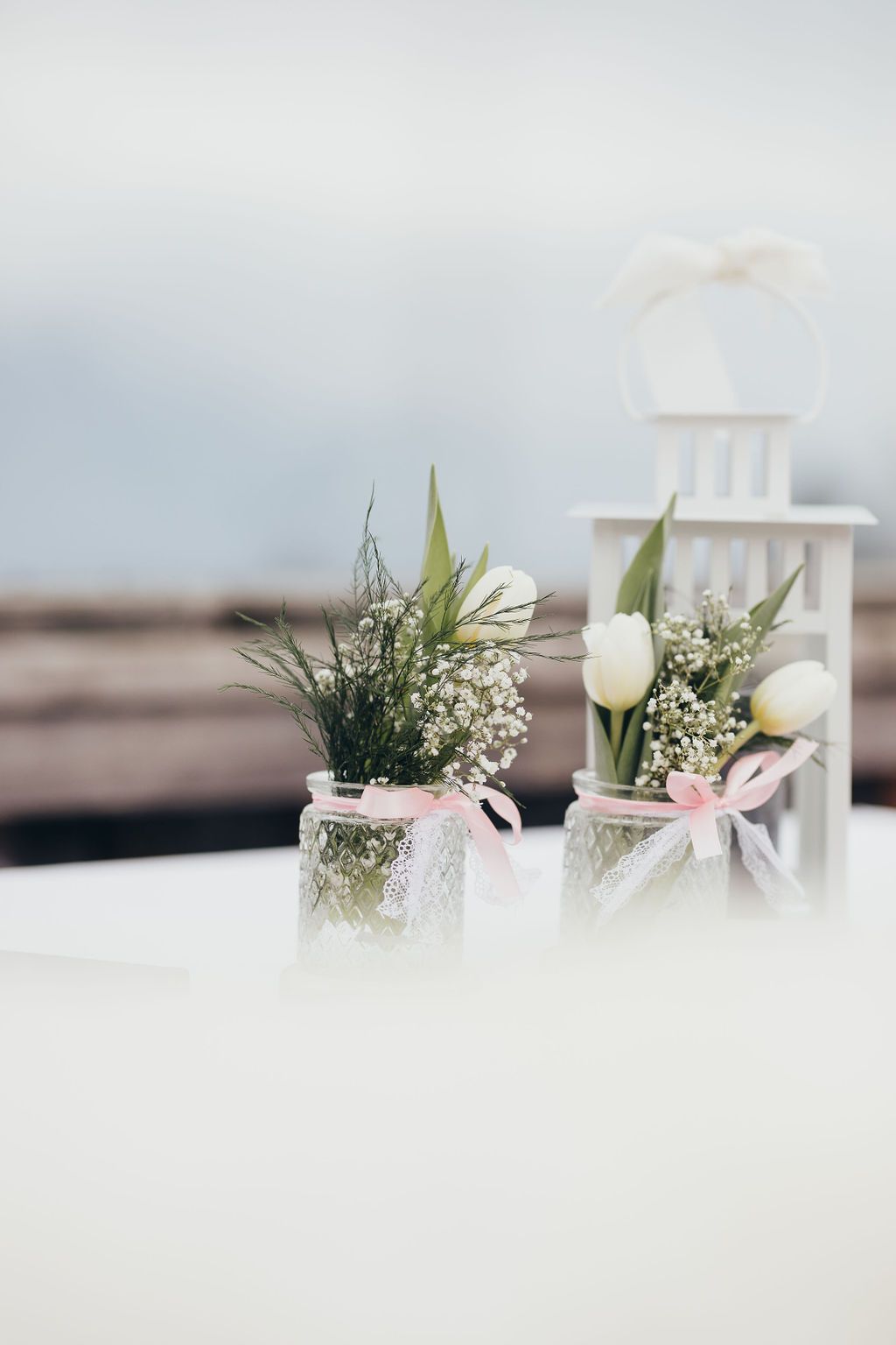 Auf einem Tisch stehen zwei mit Blumen gefüllte Töpfe.