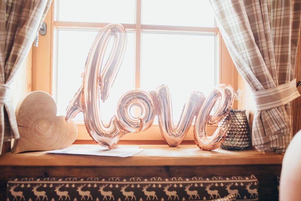 Auf einem Fensterbrett steht ein Ballon in der Form des Wortes „Love“.