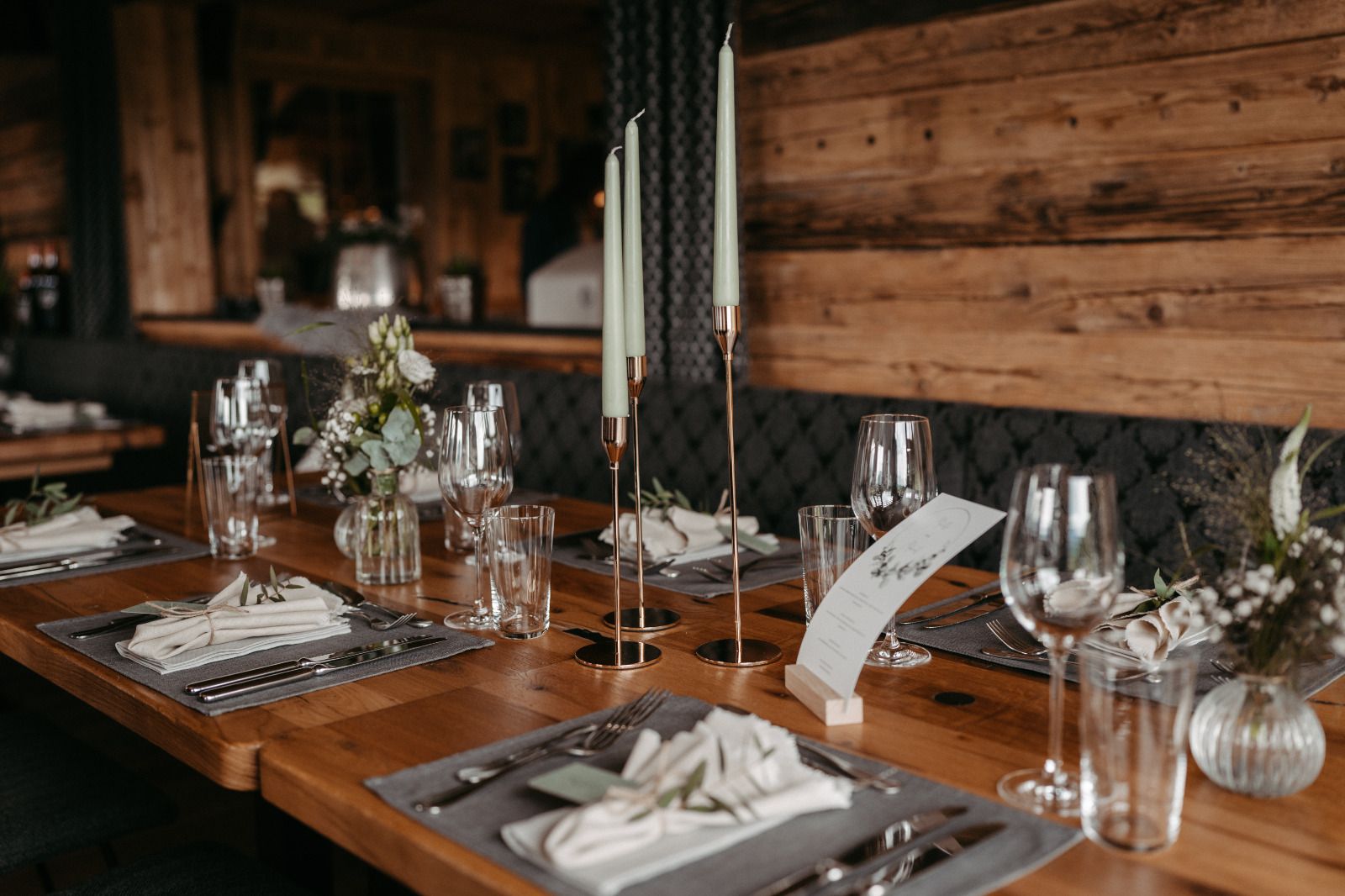 Ein für einen Hochzeitsempfang gedeckter Tisch mit Kerzen und Gläsern.