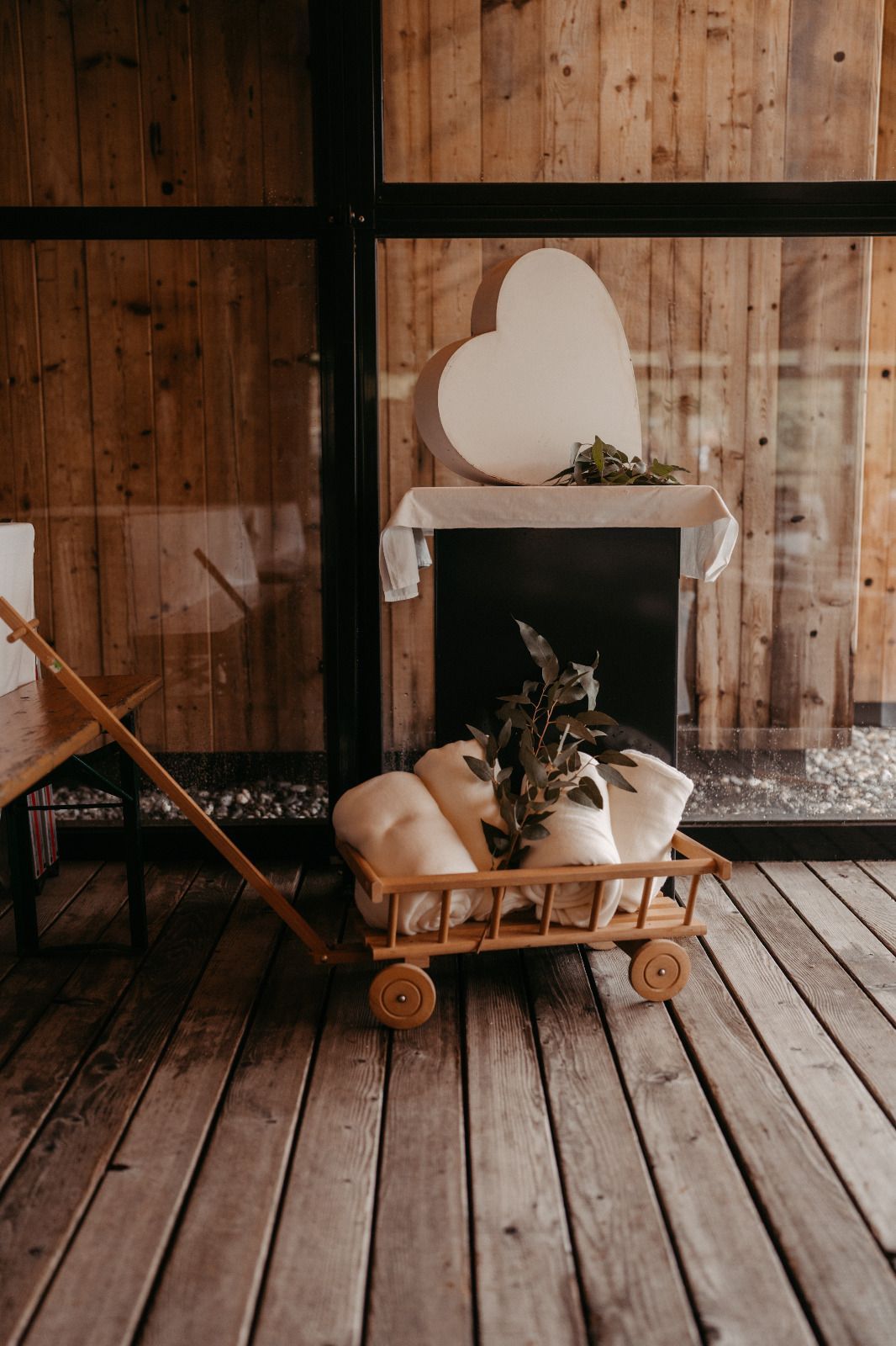 Ein Holzwagen voller Decken und einer Pflanze auf einem Holzboden.