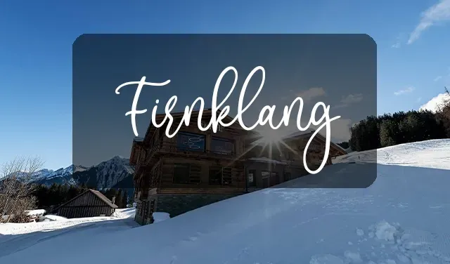 Eine Gruppe von Leuten fährt einen schneebedeckten Hang hinunter.