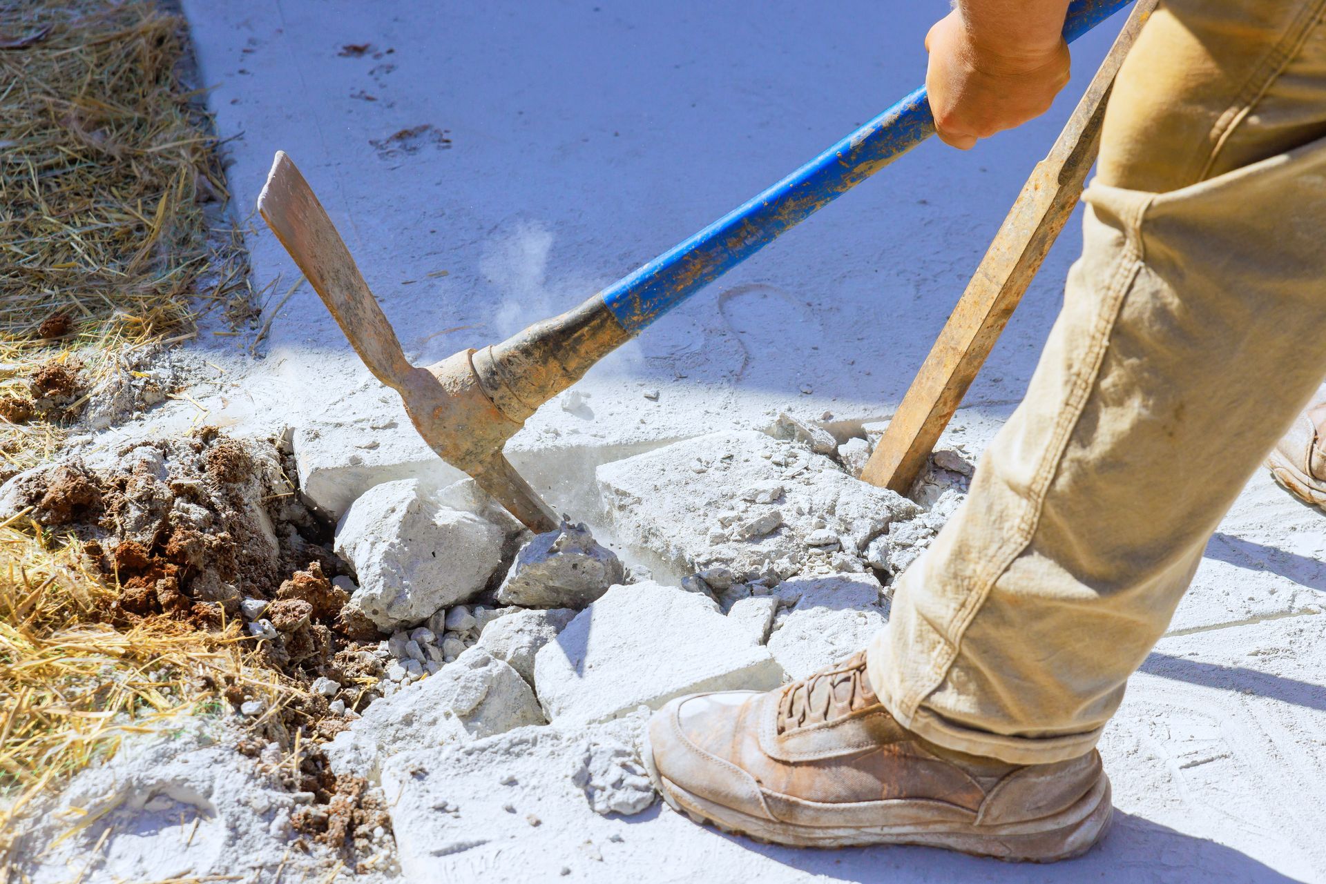 removing concrete driveway with a pick axe