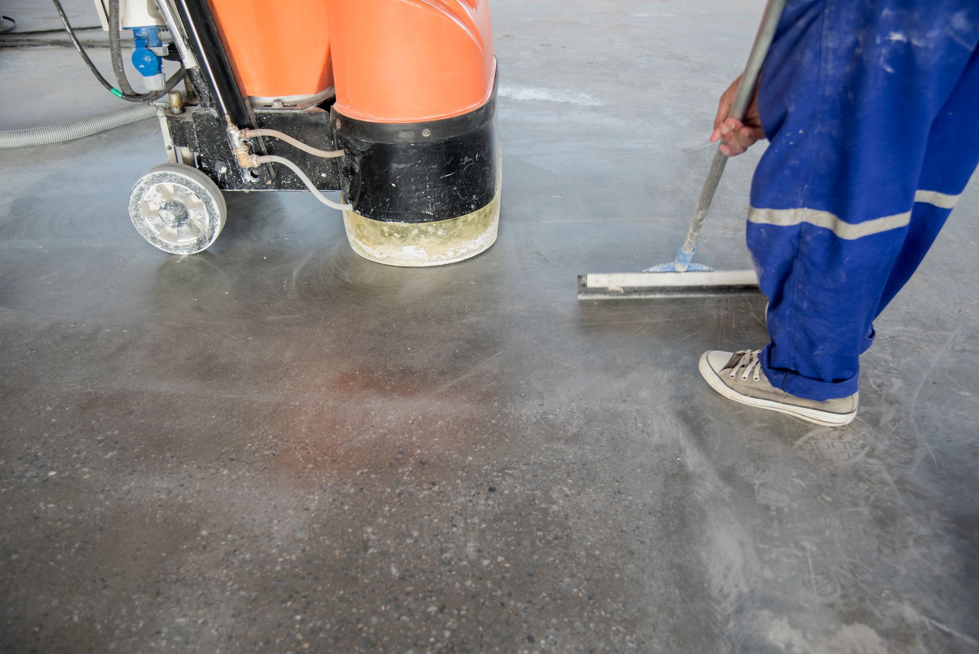 Worker finishing exposed aggregate concrete floor installation