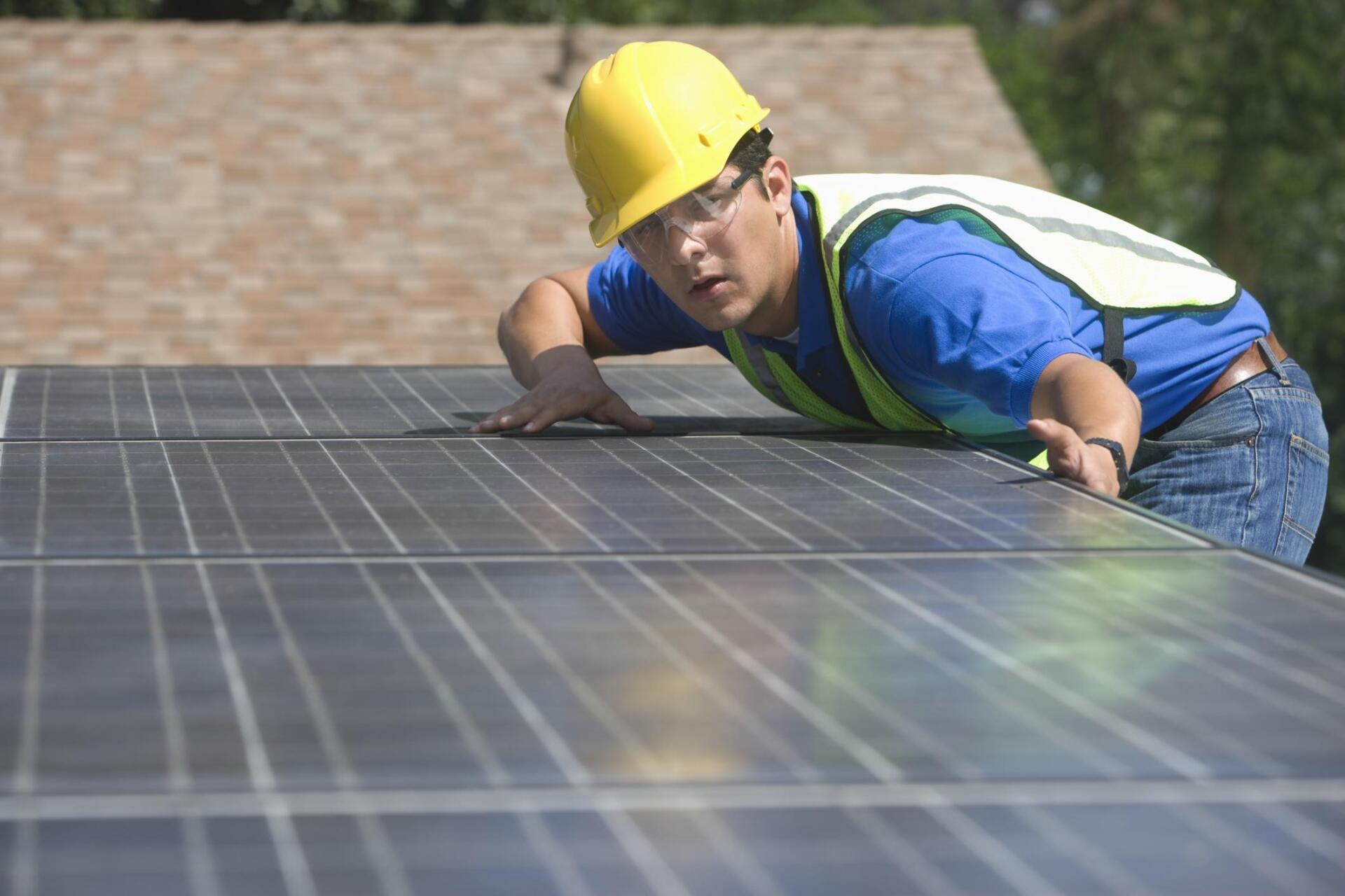 worker measuring the solar panels