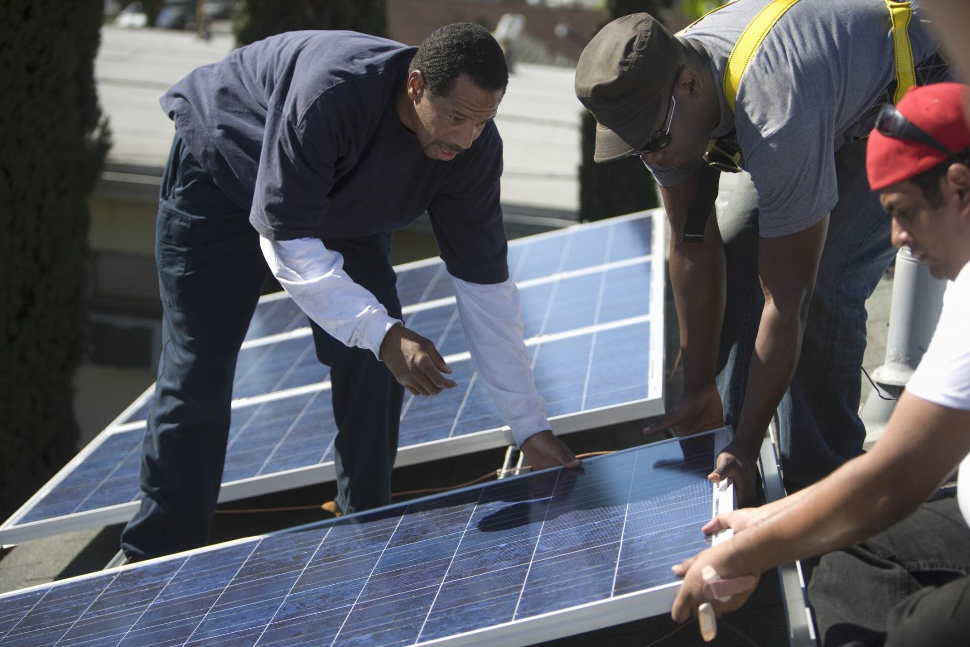workers holding the solar panel