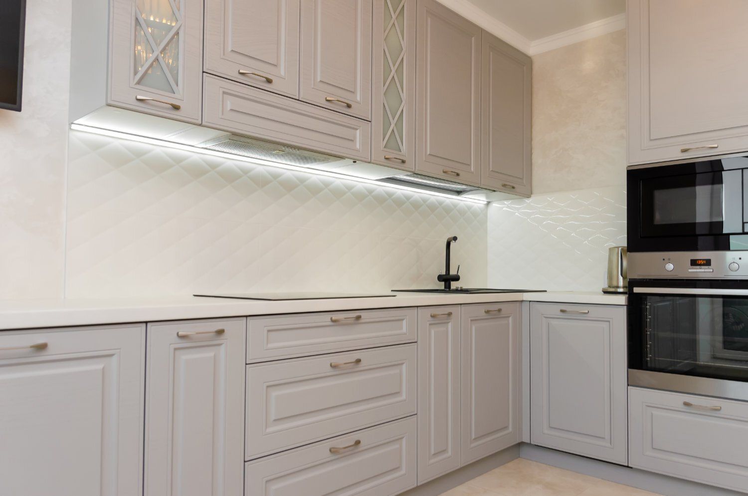 A kitchen with white cabinets and stainless steel appliances.