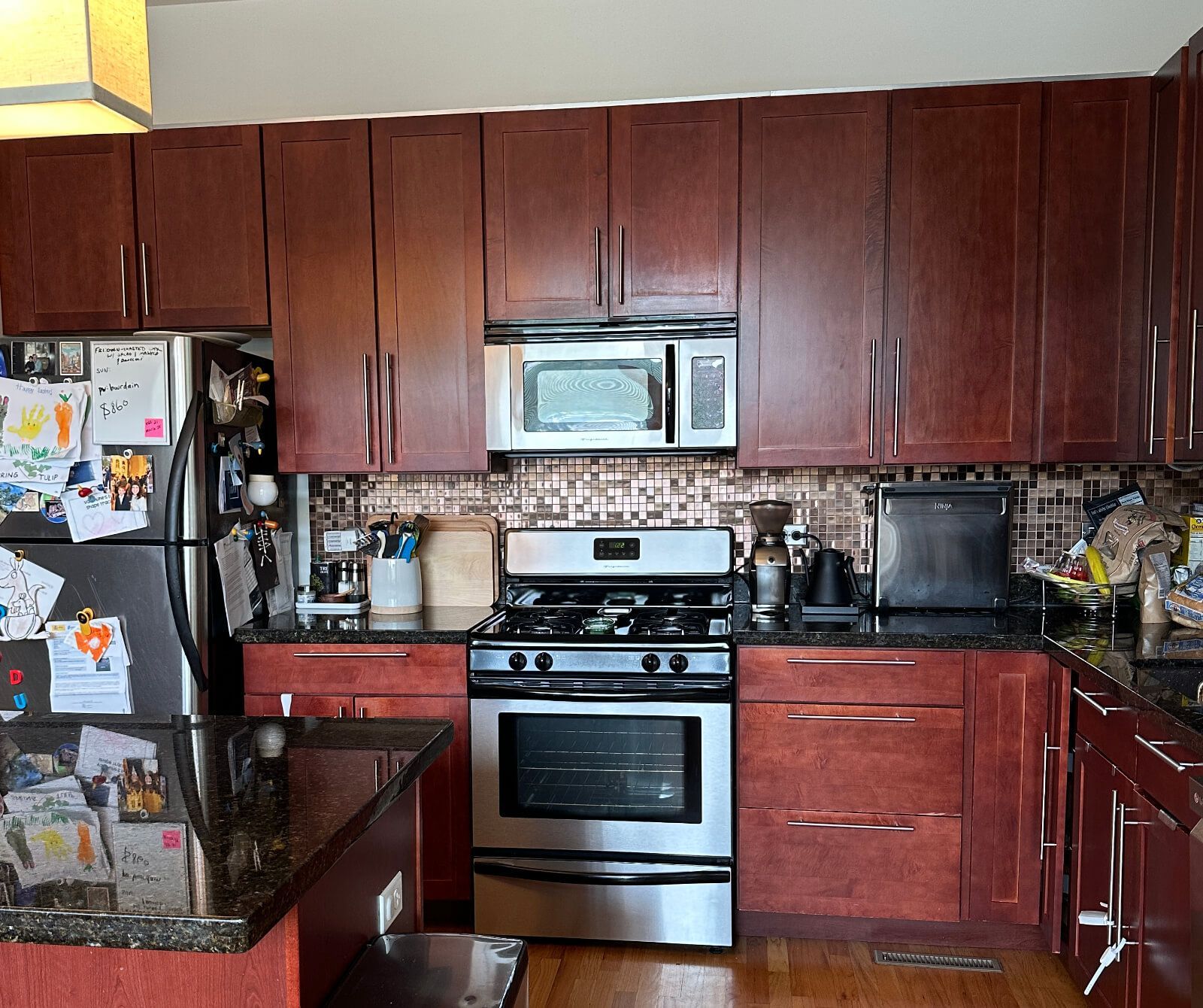 A kitchen with stainless steel appliances , granite counter tops , and wooden cabinets.