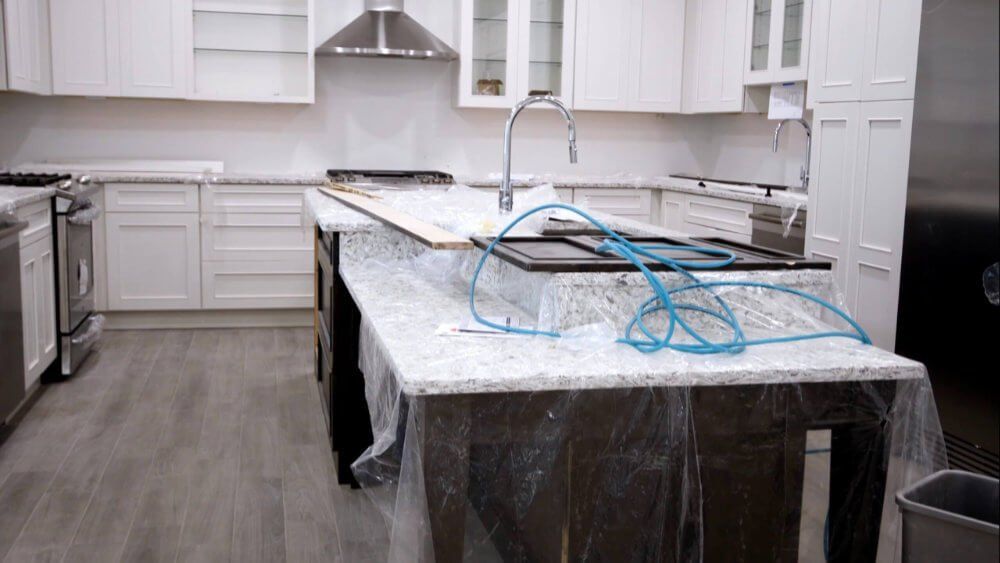 A kitchen under construction with a large island in the middle.